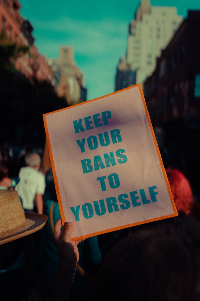 A person holds a sign that reads 'Keep Your Bans To Yourself' during a protest in New York City.