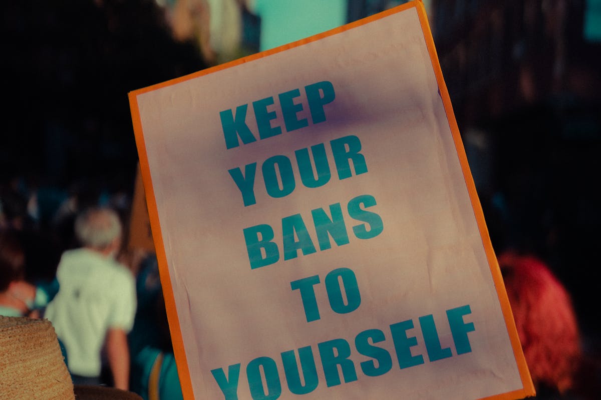 A person holds a sign that reads 'Keep Your Bans To Yourself' during a protest in New York City.